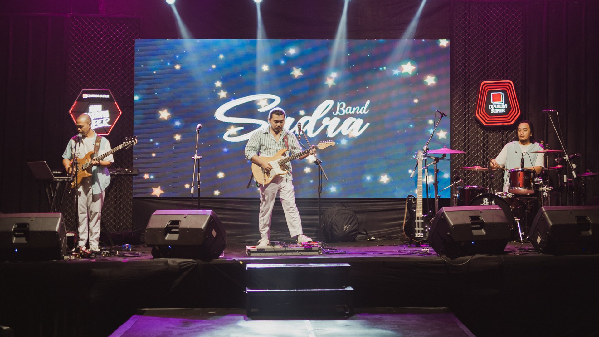 Panggung live music UJPI Entertainment dengan lighting dramatis